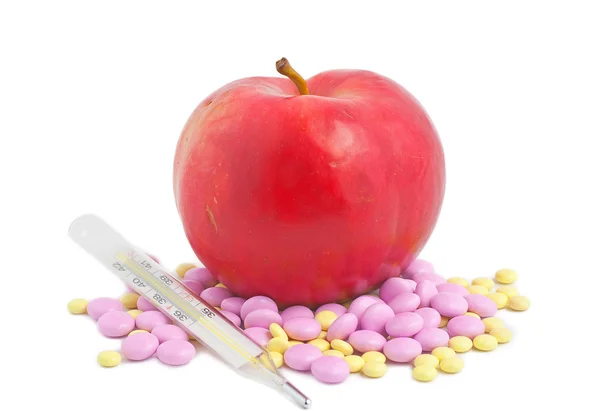 Pilules de pomme rouge et un thermomètre — Photo