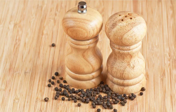 Salt and pepper grinders on a table — Stock Photo, Image