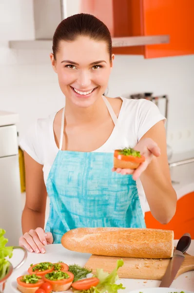 Attraktivt leende kvinna som förbereder friska fräscha smörgåsar i h — Stockfoto