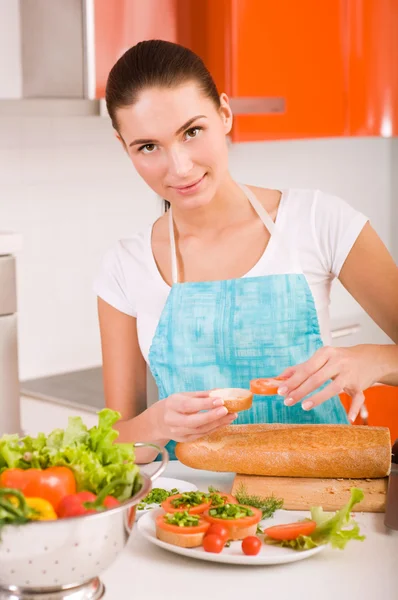 Attraktive lächelnde Frau bereitet frische gesunde Sandwiches in h zu — Stockfoto