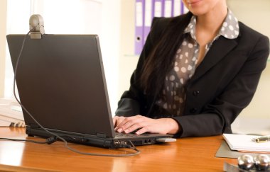 Business woman sitting in the office in front of the laptop clipart