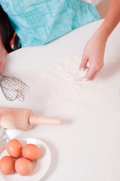 Mains de femme mélangeant la farine sur la table — Photo