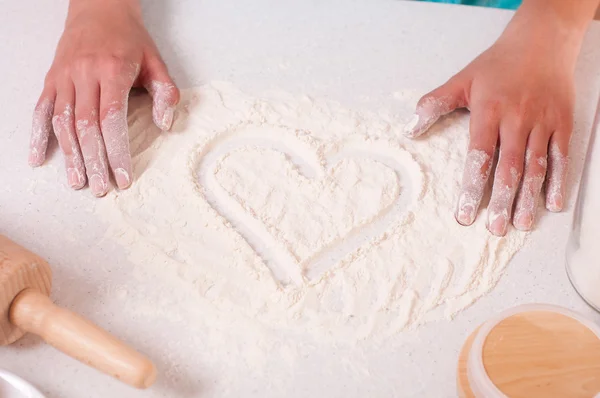 Forma do coração na farinha, feito por mãos de mulher . — Fotografia de Stock