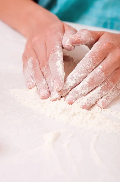 Mujer manos mezclando harina en la mesa — Foto de Stock