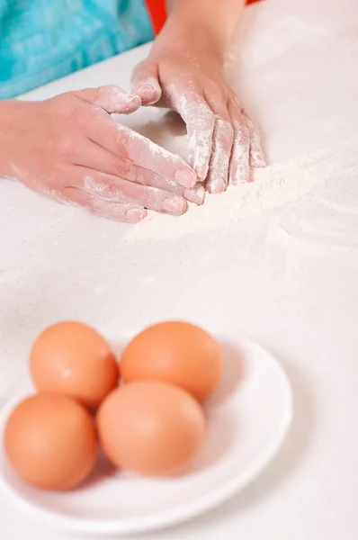 Frauenhände mischen Mehl auf dem Tisch — Stockfoto