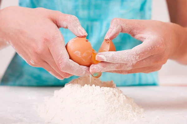 Γυναίκα χέρια σπάσιμο αυγό, σε αλεύρι — Φωτογραφία Αρχείου