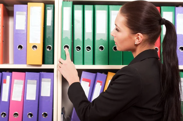 Biznes kobieta przed półki z folderów — Zdjęcie stockowe