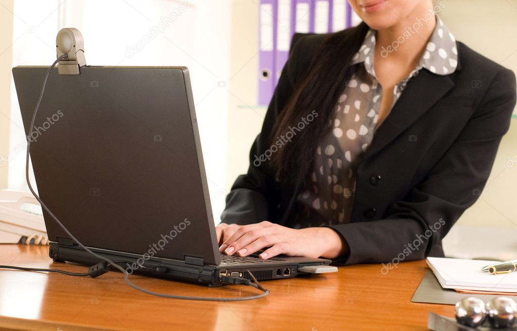 Business woman sitting in the office in front of the laptop