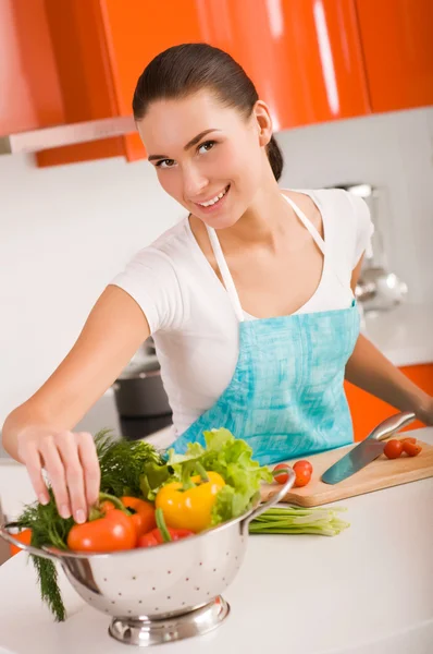 台所で料理をする美しい若い女性 ロイヤリティフリーのストック画像