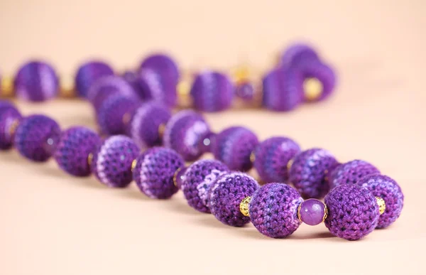 Violet beads at pink background — Stock Photo, Image