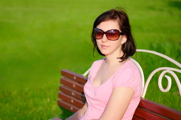 Молодая женщина на скамейке — стоковое фото
