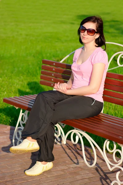 Jeune femme sur un banc — Photo