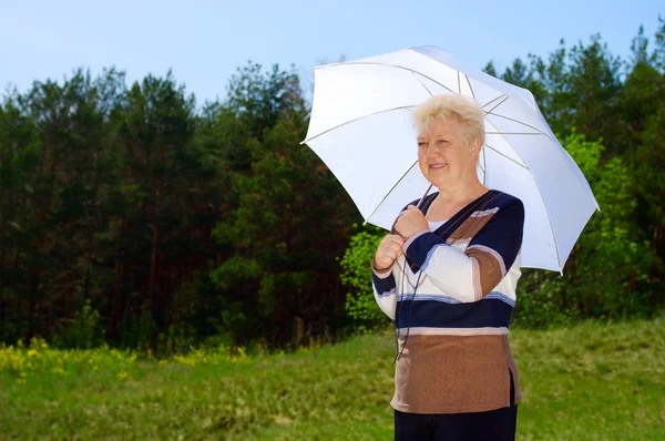 Seniorin mit Sonnenschirm — Stockfoto