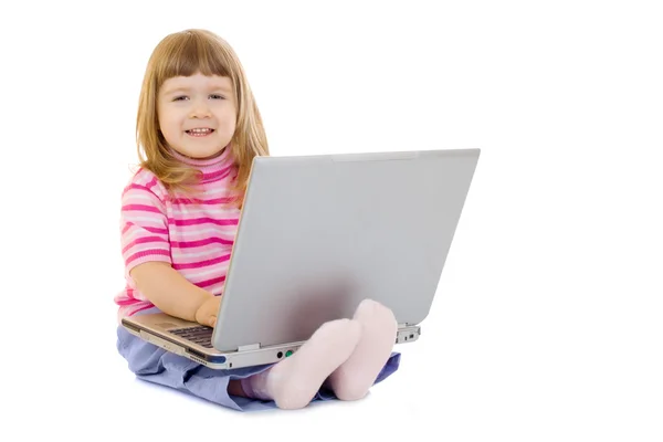 Piccola ragazza sorridente con computer portatile — Foto Stock