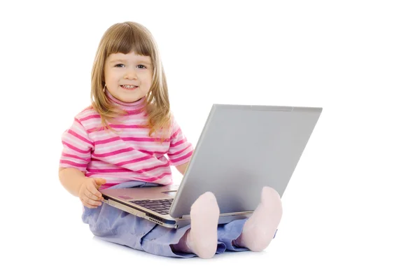 Liten leende flicka med laptop — Stockfoto
