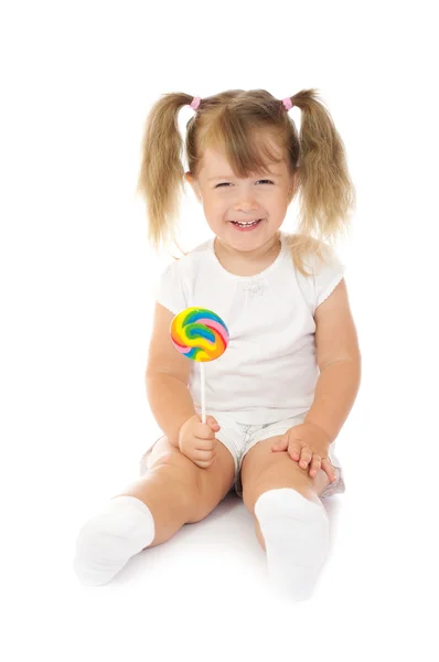Маленькая улыбающаяся девочка с леденцом — стоковое фото