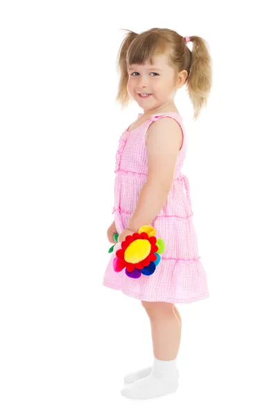 Маленькая улыбающаяся девочка с игрушечным цветком — стоковое фото