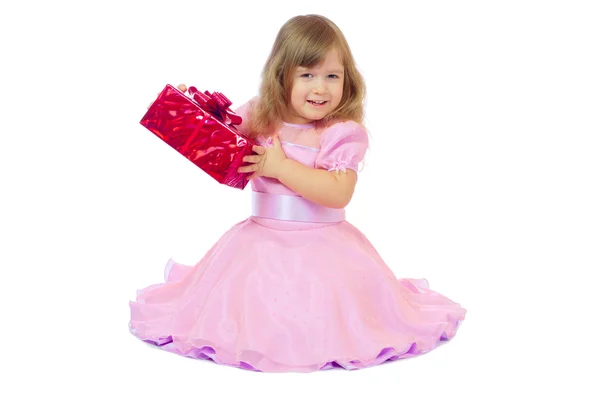 Маленькая улыбающаяся девочка с подарочной коробкой — стоковое фото