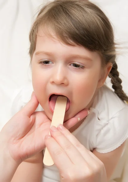 Doutor verificar garganta da menina — Fotografia de Stock
