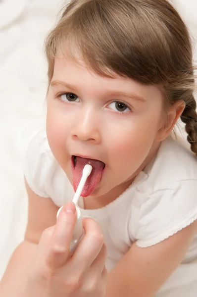 Médico espirrando aerossol uma garganta à menina — Fotografia de Stock