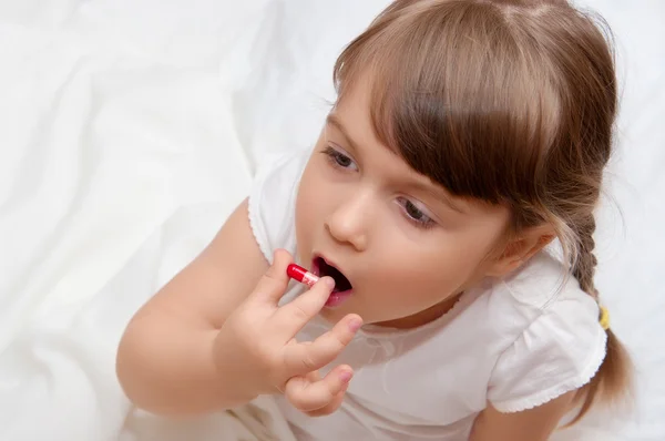 Little girl with pill — Stock Photo, Image