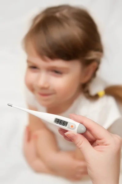 Doutor verifica a temperatura para a menina — Fotografia de Stock