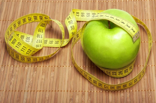 Green apple with centimeter tape — Stock Photo, Image