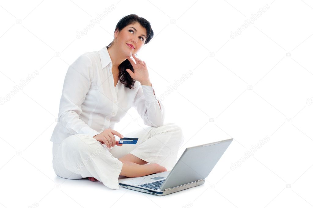 Smiling young woman with credit card and laptop