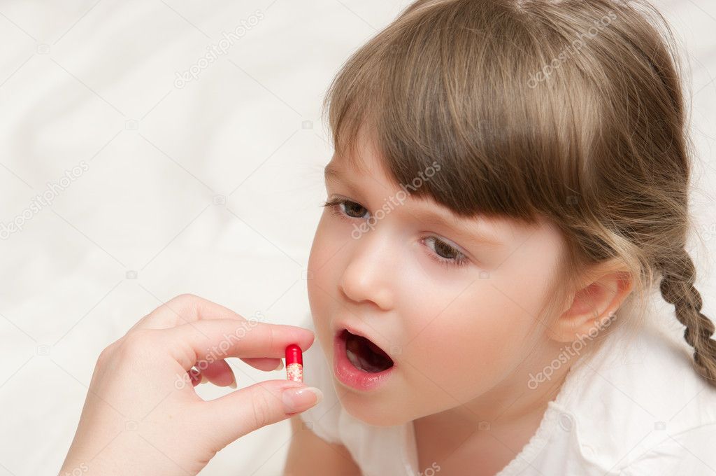Woman give pill to little girl