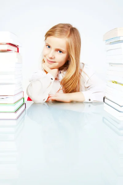 Dziewczyna siedzi w pobliżu tabela z książki — Zdjęcie stockowe