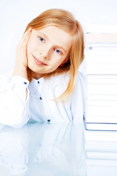 Pequena menina sorridente leitura livro na biblioteca — Fotografia de Stock