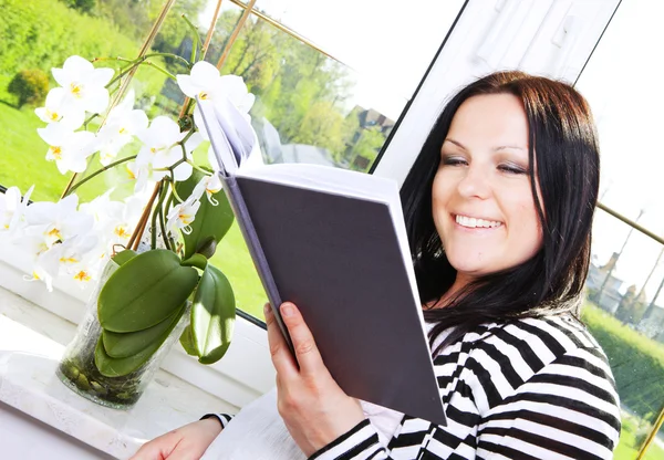 Женщина читает книгу в доме — стоковое фото