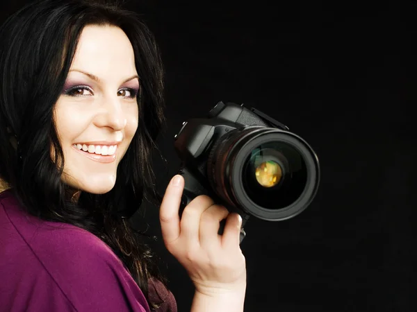 Koyu arka plan üzerinde kamera tutan fotoğrafçı kadın — Stok fotoğraf
