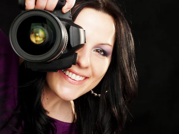 Fotografer wanita memegang kamera di atas latar belakang gelap — Stok Foto