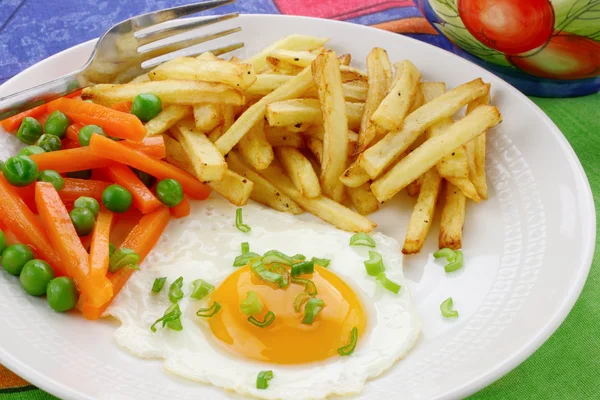 Жареное яйцо, картошка фри и овощи — стоковое фото