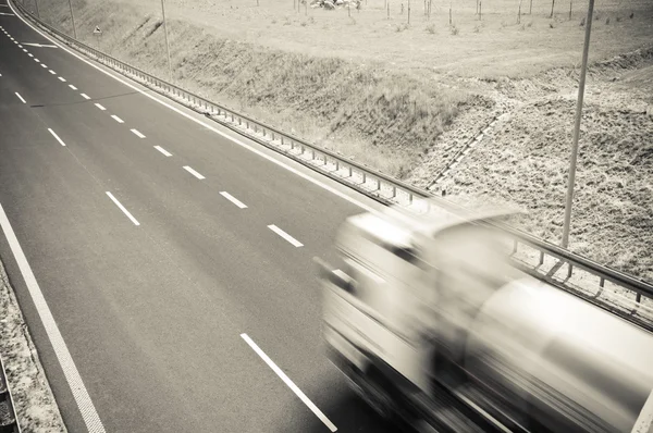Caminhão está indo ao longo da estrada de asfalto — Fotografia de Stock