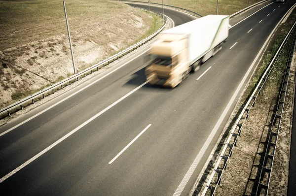Caminhão está indo ao longo da estrada de asfalto — Fotografia de Stock