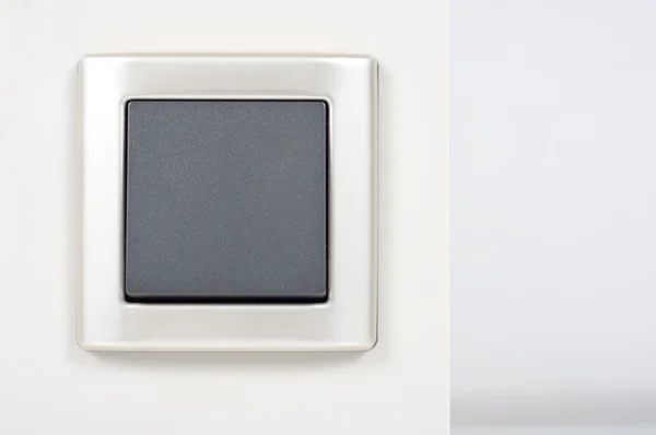 Lichtschalter an der Wand mit grauem Knopf auf silbernem Rahmen — Stockfoto