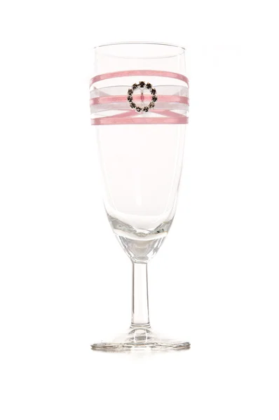 Empty glass with pink ribbon and ring on it — Stock Photo, Image