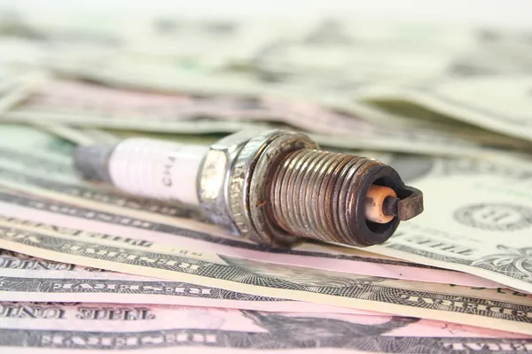 Spark plug on dollar bills — Stock Photo, Image
