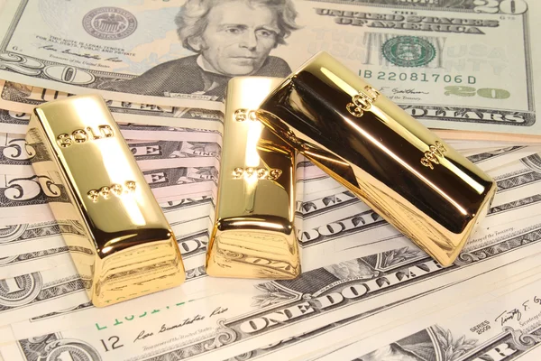Tři zlaté cihly na dolarové bankovky — Stock fotografie