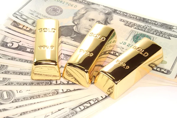 Três barras de ouro em notas de dólar — Fotografia de Stock