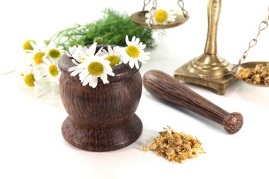 Chamomile flowers with mortar and scales clipart