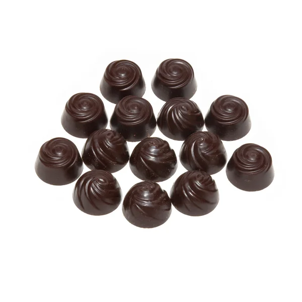 Deliciosas pralinas de chocolate escuro isoladas em branco . — Fotografia de Stock