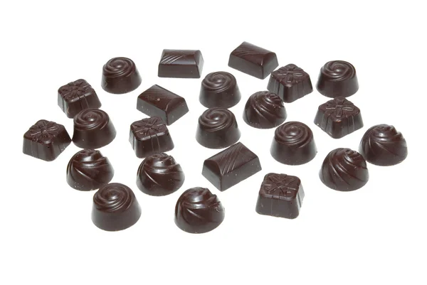 Delicious dark chocolate pralines isolated on white. — Stock Photo, Image