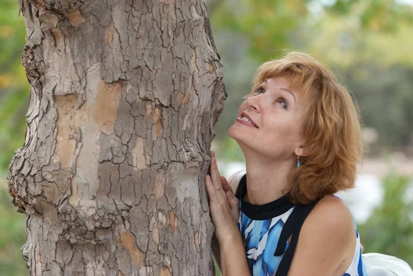 Mooie vrouw in de buurt van boom — Stockfoto