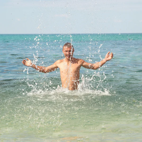 Щаслива людина в морі з бризками — стокове фото
