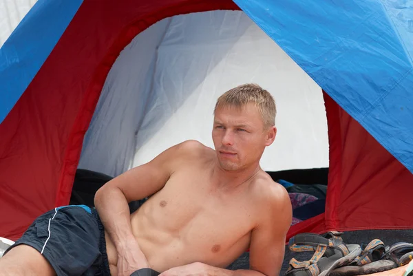Homem deitado perto da tenda — Fotografia de Stock