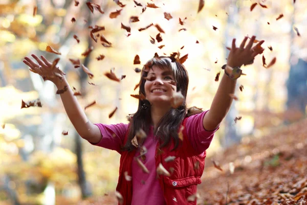 Красивая девушка с падающими листьями — стоковое фото