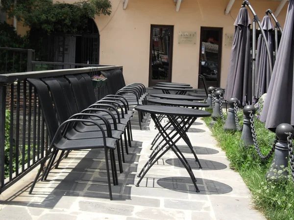 Cadeiras e mesas pretas - vista da cidade — Fotografia de Stock
